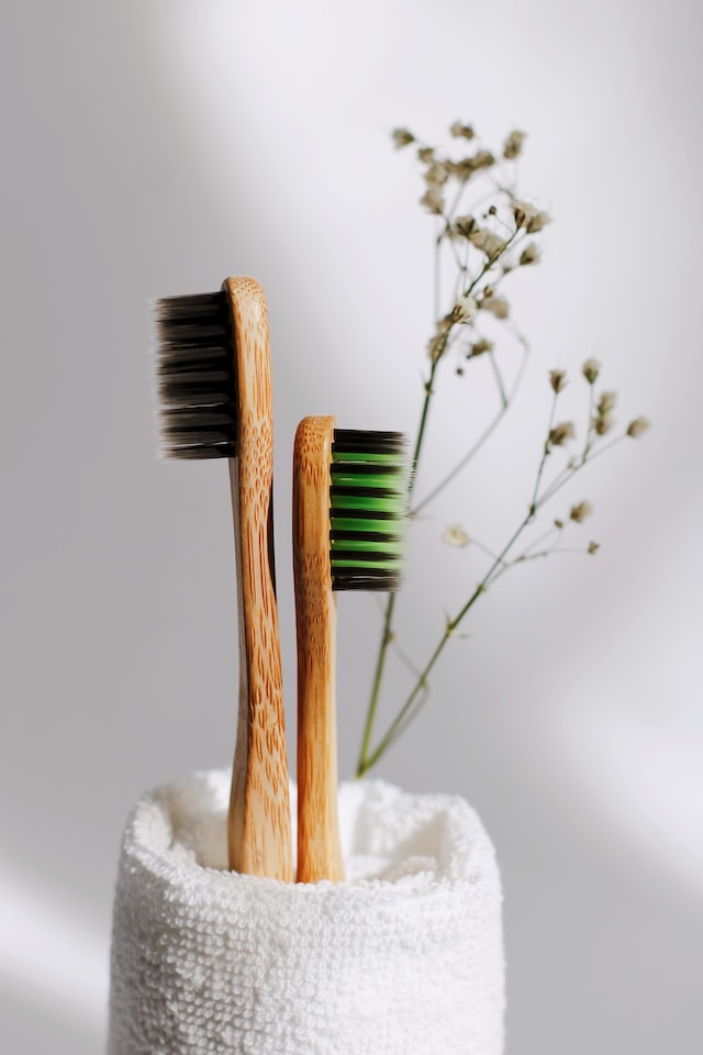 Two wooden toothbrushes inside a cup in a luxurious bathroom.